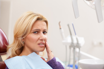 Close up of a beautiful mature woman looking exhausted suffering from toothache, copy space. Female...