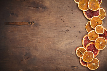 Dark brown vintage rustic wooden background with dried orange and grapefruit rings