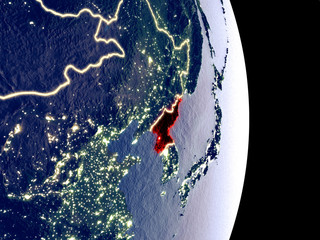 Satellite view of North Korea at night with visible bright city lights. Extremely fine detail of the plastic planet surface.
