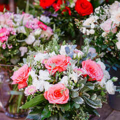 Beautiful bouquet with pink roses on a showcase in a French shop outside.