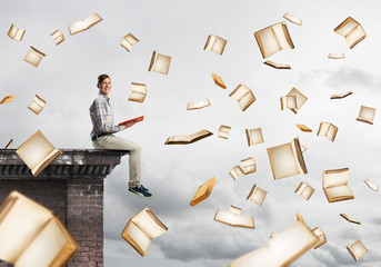 Man reading book and many of them flying in air