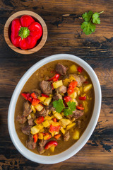 Slow cooked beef casserole. Meat and vegetables stewed in beer. Wooden rustic table, top view