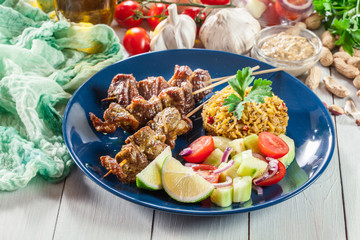 Traditional pork satay with peanut sauce and vegetables