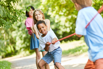 Gruppe Kinder als starkes Team beim Tauziehen