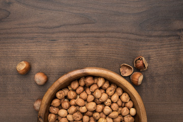 photo of a bowl full of hazelnuts on the brown wooden table