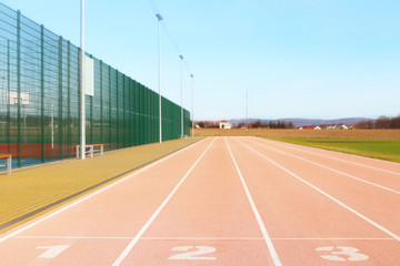 Red treadmill at the stadium. Element of a sports complex. Outdoor coating for sports. A place for...