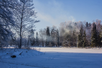 Winter landscape in clear weather. Morning bright sun. Snow plays shine. Frosty Snow Park