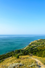 Fototapeta na wymiar Green Thracian cliffs near blue clear water of Black Sea, bulgarian coastline with hotels and golf terrain