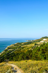 Green Thracian cliffs near blue clear water of Black Sea, bulgarian coastline with hotels and golf terrain