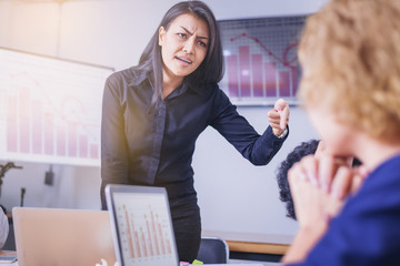 Serious woman boss scolding male employee for bad business result.