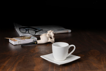 Kaffeetasse mit Tabakpfeife und Zeitung