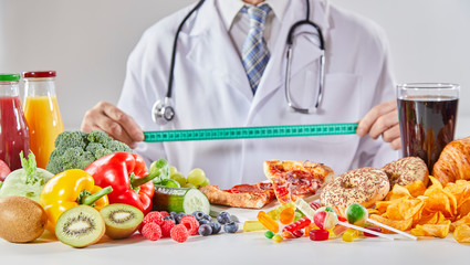 Doctor in coat holding ruler over table with food