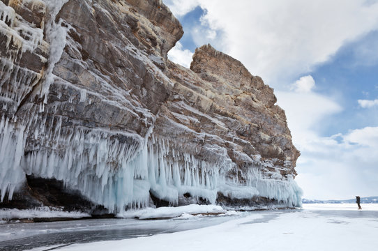 Lake Baikal. A tourist photographs the icy rocks of the Ogoy Island on a cold winter day