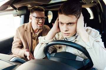 irritated father yelling at teen son in car