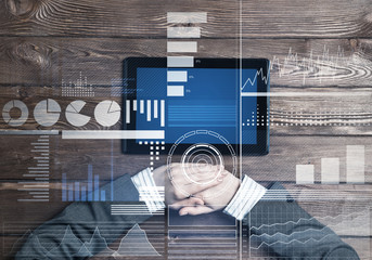 Business workplace with tablet device on wooden surface and media interface