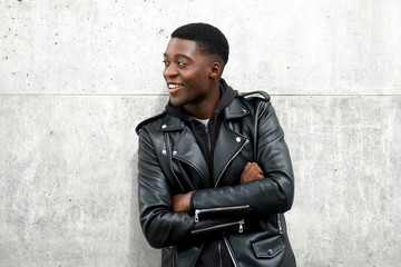 happy black guy in leather jacket with arms crossed