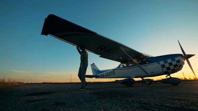 Pilot checking aiplane on an airfield, close up.