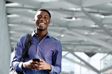 african american young man with bag and cellphone