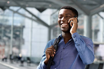Close up of smiling african american businessman talking on cellphone at station