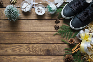 Flat lay black sneaker, mini christmas tree, gold and silver bows, Christmas ornaments on wood...