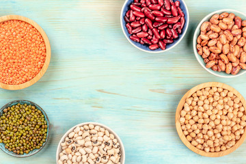 Various types of legumes, shot from the top on a teal background with a place for text. Red kidney...