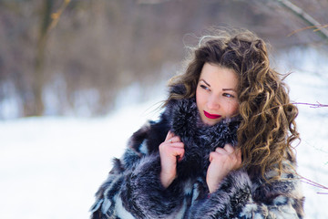 girl with curtains in winter in gray coat