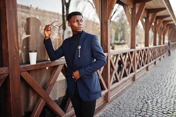 Amazingly looking african american man wear at blue blazer with brooch, black turtleneck and...