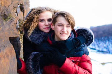 loving young couple in winter in park near the cliff