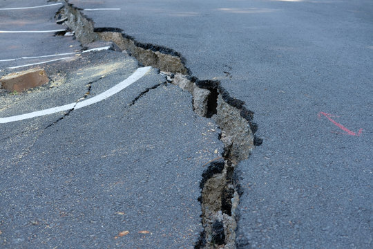 crack on asphault rural road. damaged collapsed street