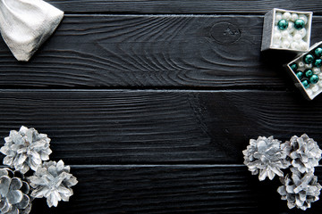Silver cones on black wooden table background. Space for text.