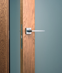 Obraz premium Close-up of modern wooden door with metal handle. Office interior