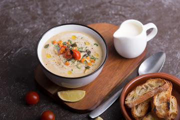 Lentil soup puree with bacon in a bowl on a dark wooden background
