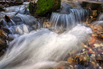 Stream flowing clean spring water. Photo taken in autumn in Russia.
