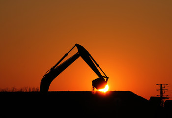 excavator working on construction site scoop silhouette