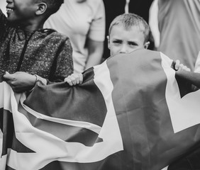Group of diverse kids showing a UK flag in a protest