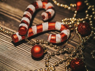 Christmas holiday decorations - beads and Christmas toys, balls, candy canes scattered on a wooden...