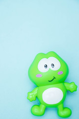 children's toy funny green frog close-up, isolated on a blue background. macro.