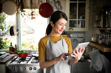 Happy woman reading a recipe from a screen