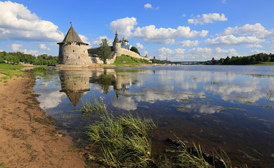 Fototapeta na wymiar Pskov, Russia, June 22, 2016. A beautiful view of the ancient tower and walls of the Pskov Kremlin with reflection in the water