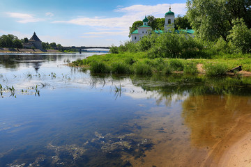 Obraz premium Monastery on the river bank in the summer. Traveling in Russia, Pskov
