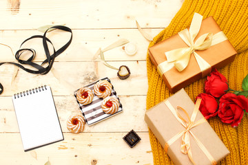 autumn and holiday concept: roses bouquet of flowers and boxes present, woolen scarf, algerian jam...
