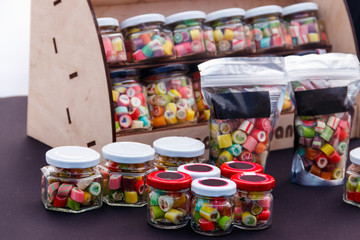 Colorful candies in jars on table