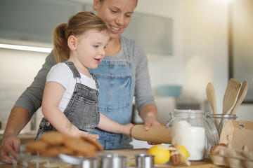   Mother and daughter baking at home