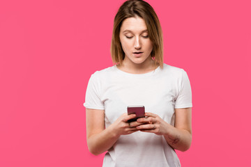 beautiful girl using smartphone isolated on pink