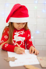 Cute girl writing a letter to Santa, white background