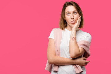 Obraz premium young woman doing grimace with tongue sticking out isolated on pink