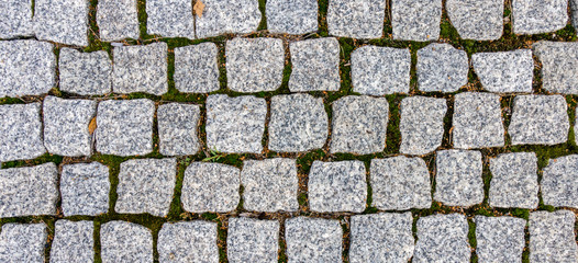 Pavement with grass and dry leaves shape as irregular pattern texture background