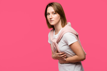 young woman having stomach pain isolated on pink