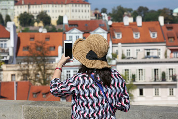 Prague, Czech Republic, September 17, 2018. A woman in a hat takes pictures on a mobile phone in...