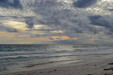 Landscape of a beach at sunset with clouds and ocean in the horizon